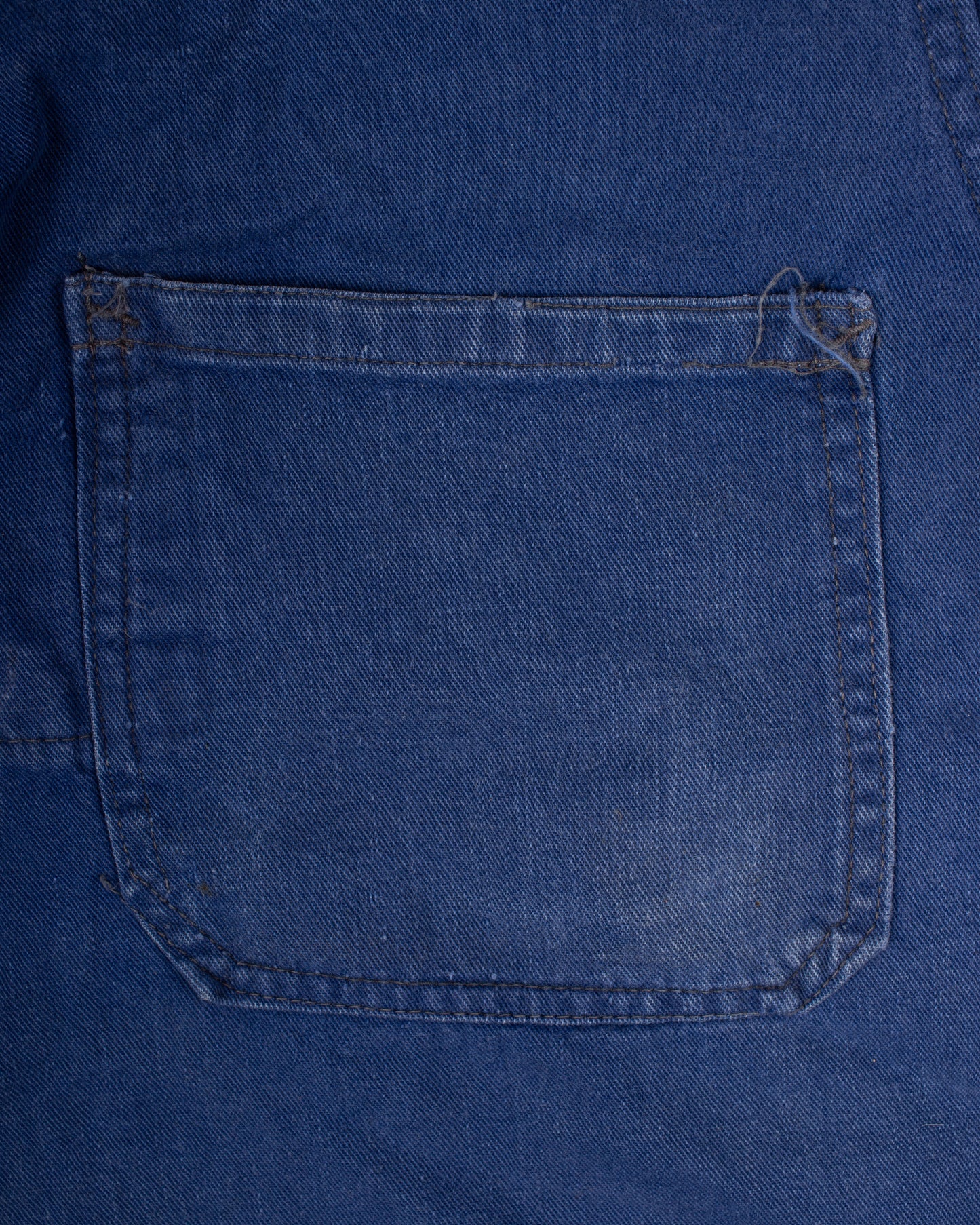 Close-up of a blue denim pocket on a garment french blue vareuse fisherman marin sailor sailing blouse smoke smock jacket overshirt 1960s