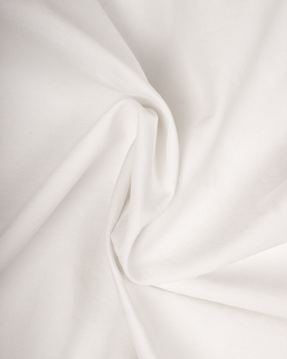 A close-up of draped white fabric with soft folds and a smooth texture.