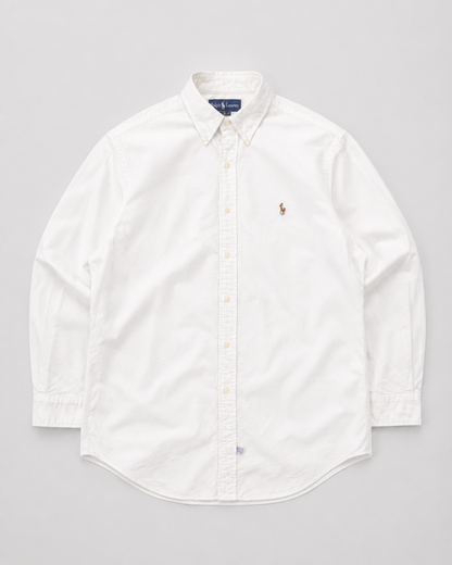 A white long-sleeve button-down shirt by Polo Ralph Lauren, featuring the signature embroidered polo player logo on the left chest, laid flat against a light gray background.